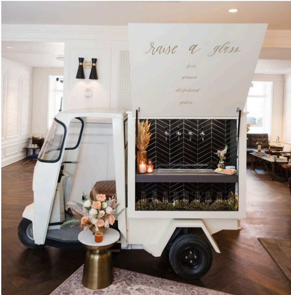 Moxie tap truck indoors with 'raise a glass' signage